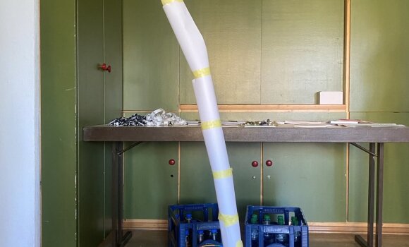 Zu sehen ist ein Turm, der aus verschiedenen Materialien zusammengebaut wurde. Hier hauptsächlich aus Papier und Dosen und Kreppband.