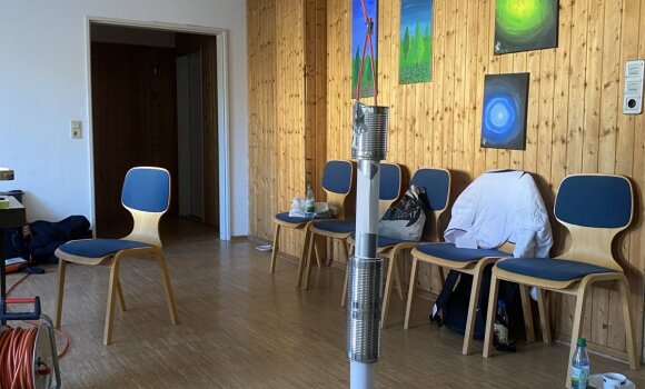 Zu sehen ist ein Turm, der aus verschiedenen Materialien zusammengebaut wurde. Hier hauptsächlich aus Papier und Dosen und Gaffatape.